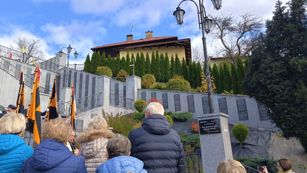 zdjęcie przedstawia grupę dorosłych osób ze sztandarami organizacji "Kolping" podczas uroczystego poświęcenia Kolpingowskiej Drogi Refleksji w Makowie Podhalańskim
