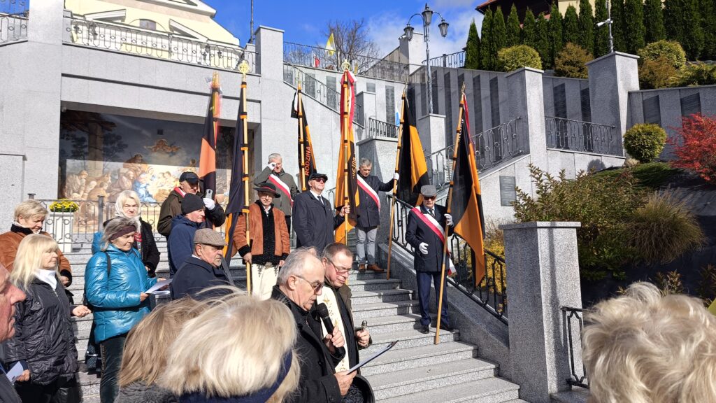 zdjęcie przedstawia grupę dorosłych osób ze sztandarami organizacji "Kolping" podczas uroczystego poświęcenia Kolpingowskiej Drogi Refleksji w Makowie Podhalańskim