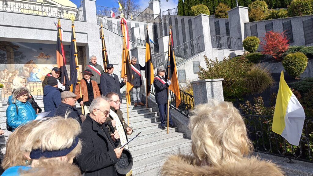 zdjęcie przedstawia grupę dorosłych osób ze sztandarami organizacji "Kolping" podczas uroczystego poświęcenia Kolpingowskiej Drogi Refleksji w Makowie Podhalańskim