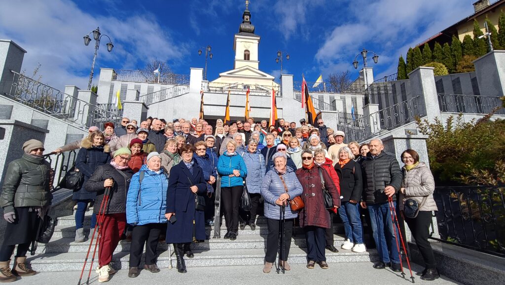 zdjęcie przedstawia grupę dorosłych osób ze sztandarami organizacji "Kolping" podczas uroczystego poświęcenia Kolpingowskiej Drogi Refleksji w Makowie Podhalańskim