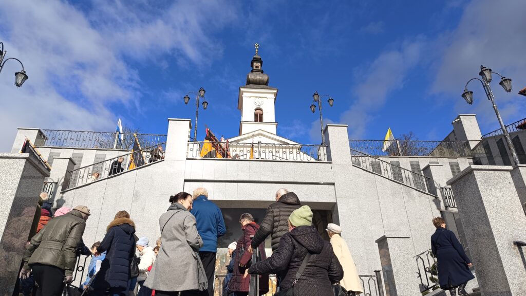 zdjęcie przedstawia grupę dorosłych osób ze sztandarami organizacji "Kolping" podczas uroczystego poświęcenia Kolpingowskiej Drogi Refleksji w Makowie Podhalańskim