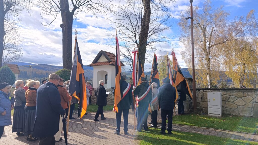 zdjęcie przedstawia grupę dorosłych osób ze sztandarami organizacji "Kolping" podczas uroczystego poświęcenia Kolpingowskiej Drogi Refleksji w Makowie Podhalańskim