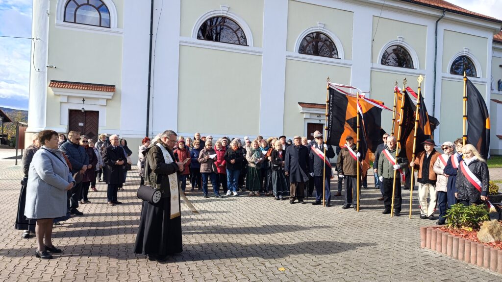 zdjęcie przedstawia grupę dorosłych osób ze sztandarami organizacji "Kolping" podczas uroczystego poświęcenia Kolpingowskiej Drogi Refleksji w Makowie Podhalańskim