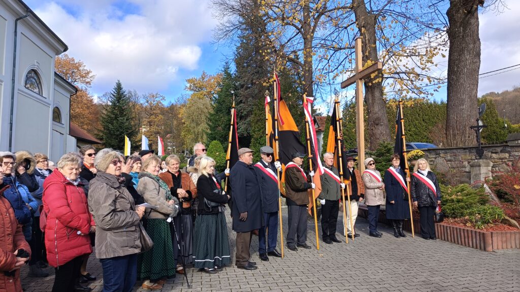 zdjęcie przedstawia grupę dorosłych osób ze sztandarami organizacji "Kolping" podczas uroczystego poświęcenia Kolpingowskiej Drogi Refleksji w Makowie Podhalańskim