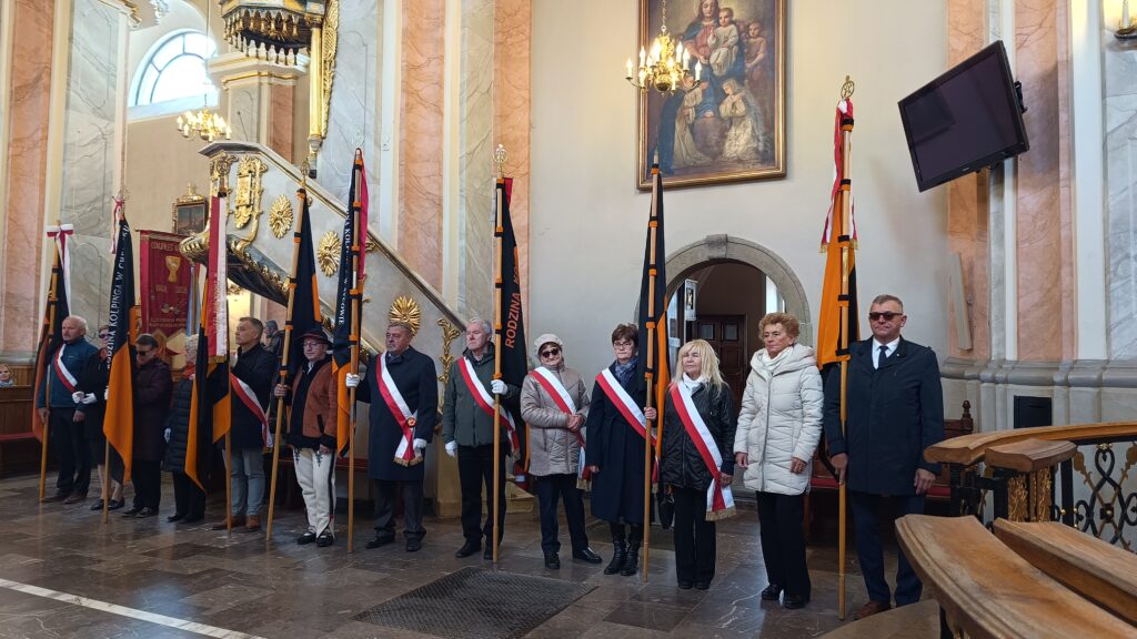 zdjęcie przedstawia grupę dorosłych osób ze sztandarami organizacji "Kolping" podczas uroczystego poświęcenia Kolpingowskiej Drogi Refleksji w Makowie Podhalańskim