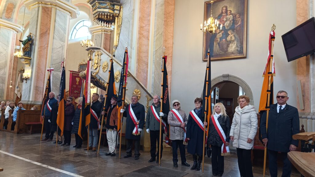zdjęcie przedstawia grupę dorosłych osób ze sztandarami organizacji "Kolping" podczas uroczystego poświęcenia Kolpingowskiej Drogi Refleksji w Makowie Podhalańskim