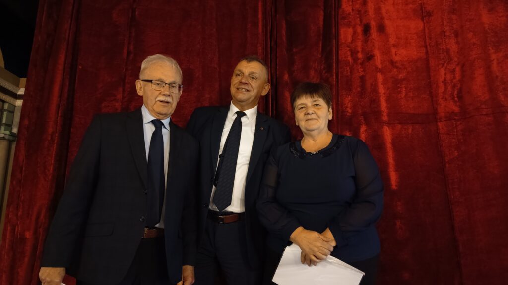 zdjęcie przedstawia 3 osoby, uśmiechnięte